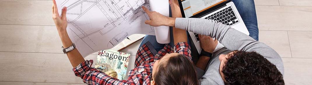 Zwei Personen sitzen auf einem Sofa. Eine Person hält einen Bauplan, während die andere auf einen Laptop schaut. Auf dem Tisch liegen Zeitschriften. Es wirkt wie eine Besprechung. Zwei Personen sitzen auf einem Sofa. Eine Person hält einen Bauplan, während die andere auf einen Laptop schaut. Auf dem Tisch liegen Zeitschriften. Es wirkt wie eine Besprechung.