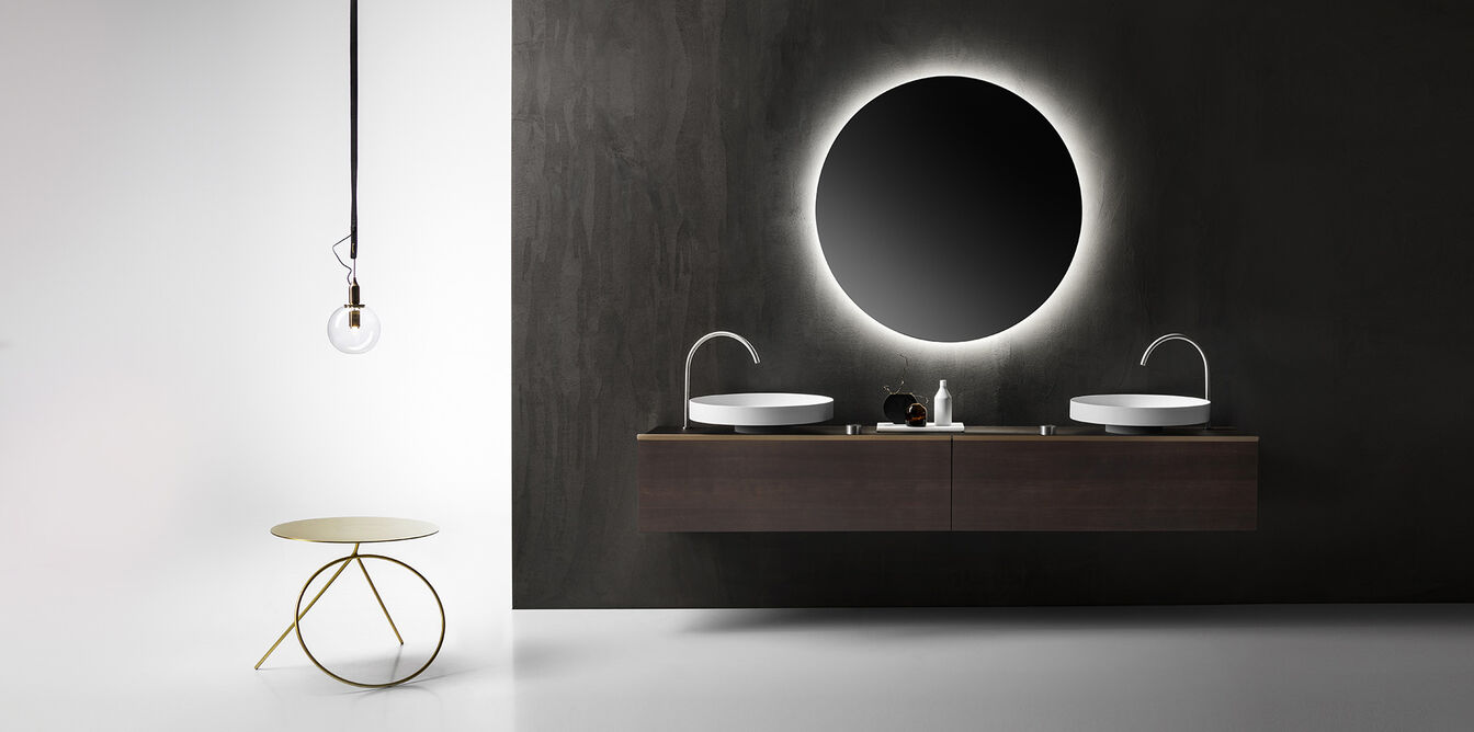 Modernes Badezimmer mit dunkler Wand, doppelt beleuchtetem Waschtisch und rundem Spiegel. Eine hängende Glühbirne und ein stylischer Beistelltisch ergänzen das Design. Modernes Badezimmer mit dunkler Wand, doppelt beleuchtetem Waschtisch und rundem Spiegel. Eine hängende Glühbirne und ein stylischer Beistelltisch ergänzen das Design.