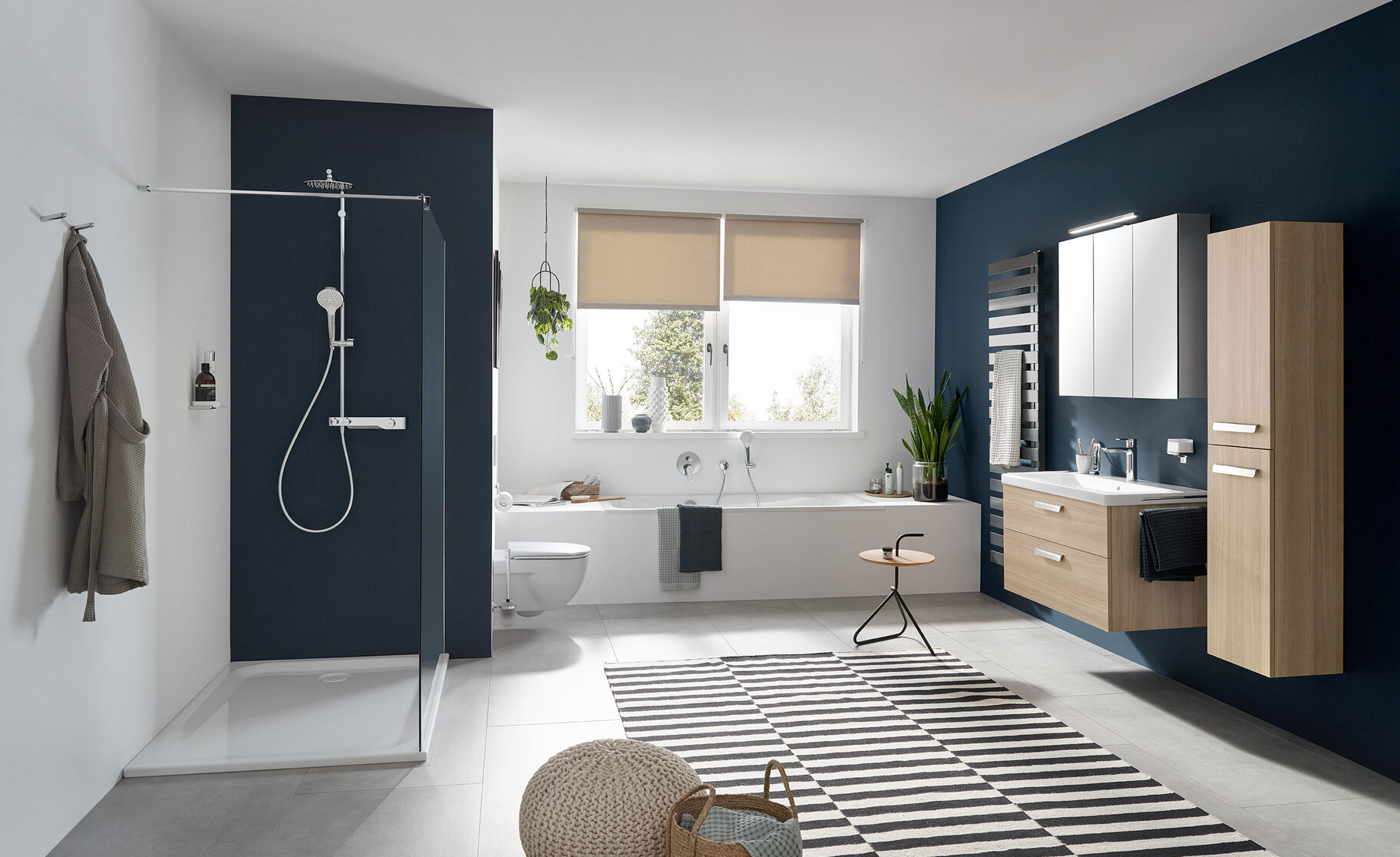 Badezimmer mit Dusche, Badewanne, schwimmendem Waschtisch und Pflanzen. Farblich in Weiß, Blau und Holz gehalten, mit grauen Fliesen. Badezimmer mit Dusche, Badewanne, schwimmendem Waschtisch und Pflanzen. Farblich in Weiß, Blau und Holz gehalten, mit grauen Fliesen.