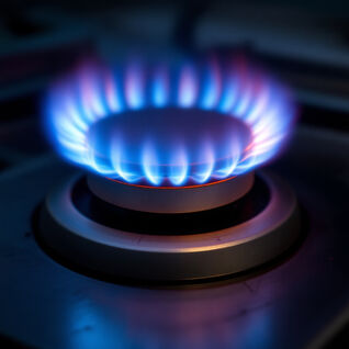 Nahaufnahme einer Gasherdflamme, die in kräftigem Blau und leichtem Rot leuchtet. Nahaufnahme einer Gasherdflamme, die in kräftigem Blau und leichtem Rot leuchtet.