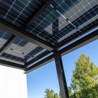 Effizientes Solardach: Moderne Energiegewinnung trifft auf stilvolle Architektur, perfekt integriert in eine gr&uuml;ne Umgebung.