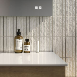 Moderner Waschtisch mit vertikal gefliester Rückwand. Pflegeprodukte stilvoll arrangiert, minimalistisches und elegantes Design. Moderner Waschtisch mit vertikal gefliester Rückwand. Pflegeprodukte stilvoll arrangiert, minimalistisches und elegantes Design.