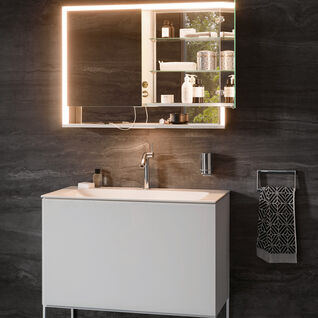 Modernes Badezimmer mit beleuchtetem Spiegelschrank, stilvollem Waschtisch und dunkler Wandverkleidung. Die Einrichtung wirkt elegant und funktional. Modernes Badezimmer mit beleuchtetem Spiegelschrank, stilvollem Waschtisch und dunkler Wandverkleidung. Die Einrichtung wirkt elegant und funktional.