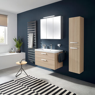 Badezimmer mit blauer Akzentwand, hellem Holzschrank, gestreiftem Teppich und minimalistischen Möbeln. Badezimmer mit blauer Akzentwand, hellem Holzschrank, gestreiftem Teppich und minimalistischen Möbeln.