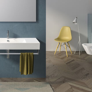 Modernes Badezimmer mit minimalistischem Design. Weiße Sanitäreinrichtungen, blaue Akzentwand, gelber Stuhl und Fischgrät-Holzboden für stilvolle Eleganz. Modernes Badezimmer mit minimalistischem Design. Weiße Sanitäreinrichtungen, blaue Akzentwand, gelber Stuhl und Fischgrät-Holzboden für stilvolle Eleganz.