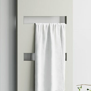 Moderner, weißer Heizkörper mit rechteckigen Ausschnitten, an dem ein weißes Handtuch hängt. Schlichtes Design vor einer weißen Wand mit einem kleinen Pflanzenakzent. Moderner, weißer Heizkörper mit rechteckigen Ausschnitten, an dem ein weißes Handtuch hängt. Schlichtes Design vor einer weißen Wand mit einem kleinen Pflanzenakzent.