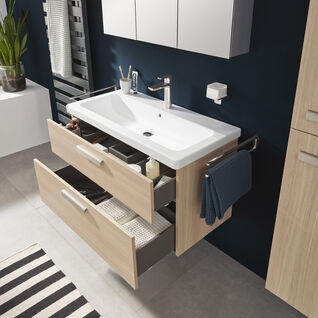 Modernes Badezimmer mit dunkelblauer Akzentwand, wandhängendem Waschbecken mit Holzschubladen und Spiegelschrank. Streifenteppich und Handtuchhalter ergänzen das Design. Modernes Badezimmer mit dunkelblauer Akzentwand, wandhängendem Waschbecken mit Holzschubladen und Spiegelschrank. Streifenteppich und Handtuchhalter ergänzen das Design.