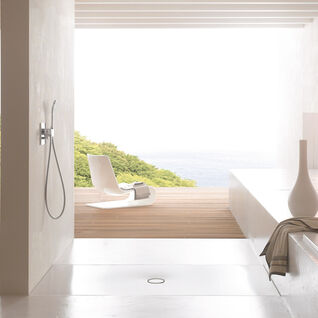 Moderne, minimalistische Dusche mit hellen, glatten Oberflächen. Eine große Öffnung bietet einen direkten Blick auf eine Terrasse mit Holzplanken und eine entspannende Aussicht auf die Natur. Moderne, minimalistische Dusche mit hellen, glatten Oberflächen. Eine große Öffnung bietet einen direkten Blick auf eine Terrasse mit Holzplanken und eine entspannende Aussicht auf die Natur.