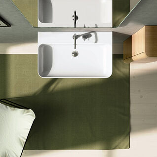 Modernes Badezimmer-Design von oben. Ein rechteckiges Waschbecken mit Spiegel, ein grüner Teppich und ein Holzschrank. Modernes Badezimmer-Design von oben. Ein rechteckiges Waschbecken mit Spiegel, ein grüner Teppich und ein Holzschrank.
