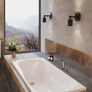 Modernes Badezimmer mit eingelassener Badewanne und Blick auf die Landschaft. Schlichte Wandleuchten, Naturmaterialien und Pflanzen sorgen für Eleganz. Modernes Badezimmer mit eingelassener Badewanne und Blick auf die Landschaft. Schlichte Wandleuchten, Naturmaterialien und Pflanzen sorgen für Eleganz.