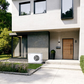 Ein stilvolles, modernes Haus mit einer Wärmepumpe von Stibel Eltron im Garten. Der Eingang ist mit einer Holztür und einer dekorativen Pflanze gestaltet. Luft Wasser Wärmepumpe außen