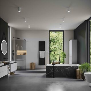 Ger&auml;umiges, modernes Badezimmer mit einer freistehenden Badewanne aus schwarzem Marmor. Doppelwaschbecken mit runden Spiegeln und zeitgem&auml;&szlig;en Leuchten. 