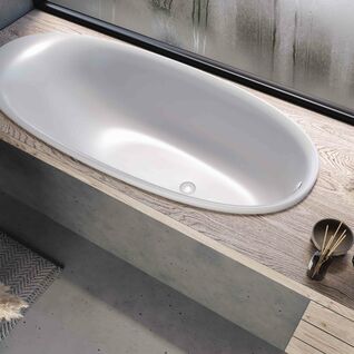 Freistehende, oval geformte Badewanne in mattem Weiß, bündig in eine Holzkonsole eingelassen, minimalistisch inszeniert mit natürlichen Materialien. Freistehende, oval geformte Badewanne in mattem Weiß, bündig in eine Holzkonsole eingelassen, minimalistisch inszeniert mit natürlichen Materialien.