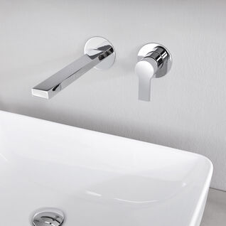 Wandmontierte Chromarmatur über einem modernen, rechteckigen Waschbecken. Minimalistisches Design mit schlichtem, elegantem Look. Wandmontierte Chromarmatur über einem modernen, rechteckigen Waschbecken. Minimalistisches Design mit schlichtem, elegantem Look.