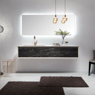 Modernes Badezimmer mit beleuchtetem Spiegel, hängendem Waschtisch in Marmoroptik, eleganter Beleuchtung und stilvollen Accessoires. Gemütlich und schick. Modernes Badezimmer mit beleuchtetem Spiegel, hängendem Waschtisch in Marmoroptik, eleganter Beleuchtung und stilvollen Accessoires. Gemütlich und schick.