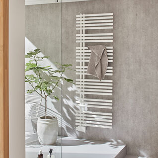 Modernes Badezimmer mit grauem Beton, weißem Handtuchheizkörper und Glasdusche. Eine große Pflanze und natürliche Beleuchtung ergänzen den Raum. Modernes Badezimmer mit grauem Beton, weißem Handtuchheizkörper und Glasdusche. Eine große Pflanze und natürliche Beleuchtung ergänzen den Raum.