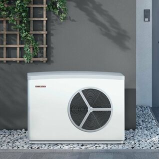 Das Bild zeigt eine Außeneinheit einer Wärmepumpe von Stiebel Eltron neben einer Haustür, umgeben von Kieselsteinen und Kletterpflanzen an der Wand. Das Bild zeigt eine Außeneinheit einer Wärmepumpe von Stiebel Eltron neben einer Haustür, umgeben von Kieselsteinen und Kletterpflanzen an der Wand.