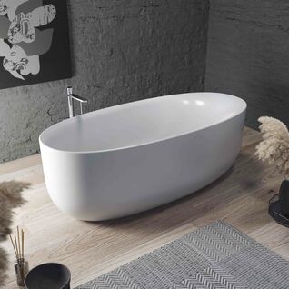 Freistehende wei&szlig;e Badewanne auf Holzuntergrund, graue Wand, moderne Dekoration mit Pflanzen und Kunstwerk im Hintergrund.