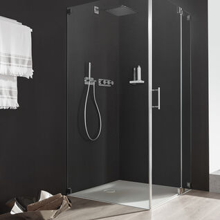 Moderne Duschkabine mit klaren Glaswänden, dunklem Innenraum, silbernen Armaturen und Ablage. Helle Holzböden bieten einen warmen Kontrast. Moderne Duschkabine mit klaren Glaswänden, dunklem Innenraum, silbernen Armaturen und Ablage. Helle Holzböden bieten einen warmen Kontrast.