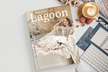Ein Magazin mit dem Titel "Lagoon" liegt auf einem Tisch. Daneben sind eine Tastatur, eine Tasse Kaffee, Büroklammern und ein Notizblock zu sehen. Ein Magazin mit dem Titel "Lagoon" liegt auf einem Tisch. Daneben sind eine Tastatur, eine Tasse Kaffee, Büroklammern und ein Notizblock zu sehen.