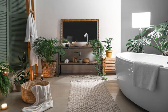 Ein modernes Badezimmer mit einer freistehenden Badewanne und stilvoller Dekoration. Pflanzen sorgen für eine frische Atmosphäre, während Kerzen und ein Teppich für Gemütlichkeit sorgen. Ein modernes Badezimmer mit einer freistehenden Badewanne und stilvoller Dekoration. Pflanzen sorgen für eine frische Atmosphäre, während Kerzen und ein Teppich für Gemütlichkeit sorgen.