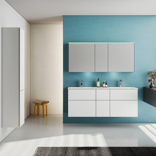 Modernes Badezimmer mit schwebenden weißen Schränken, blauer Akzentwand, großen Fenstern und minimalistischem Design.