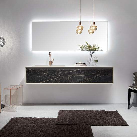 Elegantes Bad mit beleuchtetem Spiegel, schwarzem Waschtisch mit Marmordetails, modernen Pendelleuchten, dekorativem Stuhl und Stehlampe. Luxuriös und zeitgenössisch. Elegantes Bad mit beleuchtetem Spiegel, schwarzem Waschtisch mit Marmordetails, modernen Pendelleuchten, dekorativem Stuhl und Stehlampe. Luxuriös und zeitgenössisch.