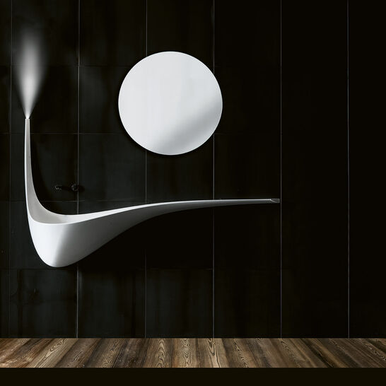 Modernes Badezimmer mit futuristischem Design. Weiße, geschwungene Waschtischform und runder Spiegel vor schwarzer Wand. Dunkler Holzboden ergänzt den Look. Modernes Badezimmer mit futuristischem Design. Weiße, geschwungene Waschtischform und runder Spiegel vor schwarzer Wand. Dunkler Holzboden ergänzt den Look.