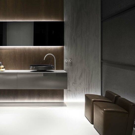 Elegantes, modernes Badezimmerdesign mit dunklen Tönen und indirekter Beleuchtung. Ein stilvolles Waschbecken auf einem schwimmenden Waschtisch, ergänzt durch luxuriöse Sitzelemente. Elegantes, modernes Badezimmerdesign mit dunklen Tönen und indirekter Beleuchtung. Ein stilvolles Waschbecken auf einem schwimmenden Waschtisch, ergänzt durch luxuriöse Sitzelemente.