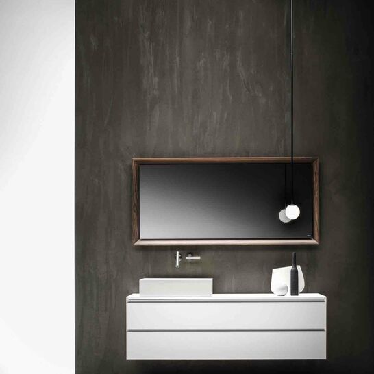 Ein stilvolles Badezimmer mit dunkler Wand, einem schwebenden wei&szlig;en Waschtisch und rechteckigem Spiegel. Eine h&auml;ngende Lampe sorgt f&uuml;r modernes Flair.