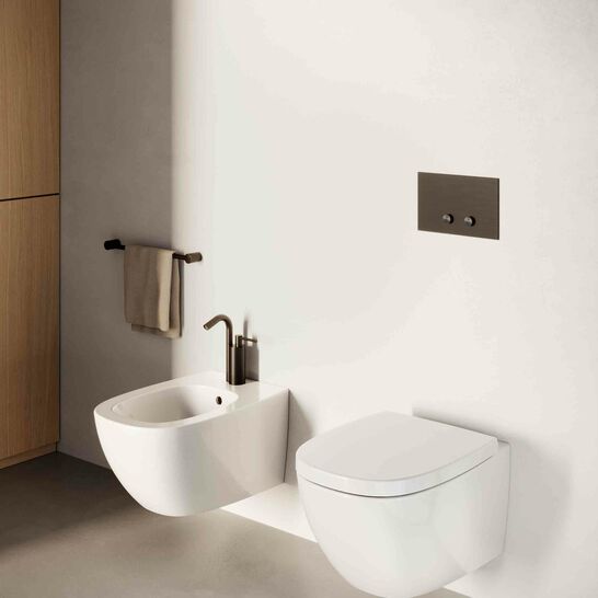Modernes Badezimmer mit wandh&auml;ngendem WC und Bidet. Dezente Gestaltung mit einem schwarzen Sp&uuml;ltastenfeld und einem Handtuchhalter an der Seite. Schlichter, eleganter Look.