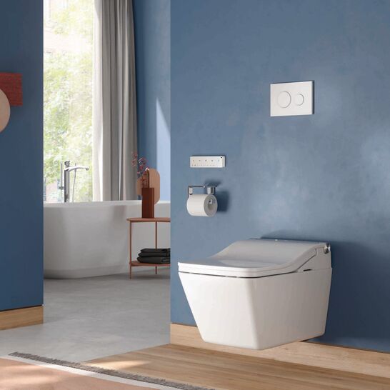 Modernes Bad mit wandh&auml;ngendem WC vor mattblauer Wand, klaren Linien und warmem Holzboden; im Hintergrund eine freistehende Wanne am Fenster.