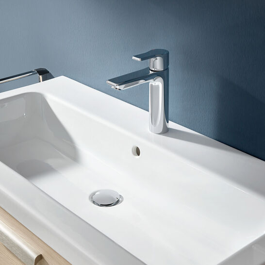 Modernes Waschbecken mit rechteckiger Form und eleganter Chromarmatur. Blaue Wand im Hintergrund, schlichtes und stilvolles Design. Modernes Waschbecken mit rechteckiger Form und eleganter Chromarmatur. Blaue Wand im Hintergrund, schlichtes und stilvolles Design.
