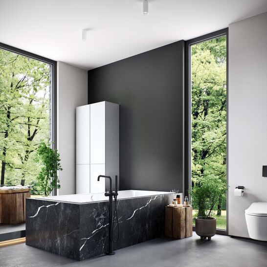 Modernes Badezimmer mit gro&szlig;er schwarzer Badewanne, gro&szlig;en Fenstern, die Natur zeigen, und stilvollen Elementen aus Holz und Gr&uuml;npflanzen.