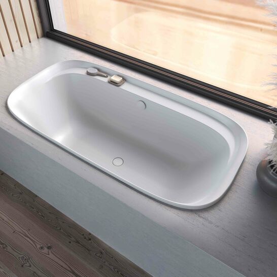 Elegante Einbau-Badewanne mit schlichtem, modernem Design neben einem gro&szlig;en Fenster. Helle, beruhigende Umgebung mit nat&uuml;rlichem Lichteinfall.
