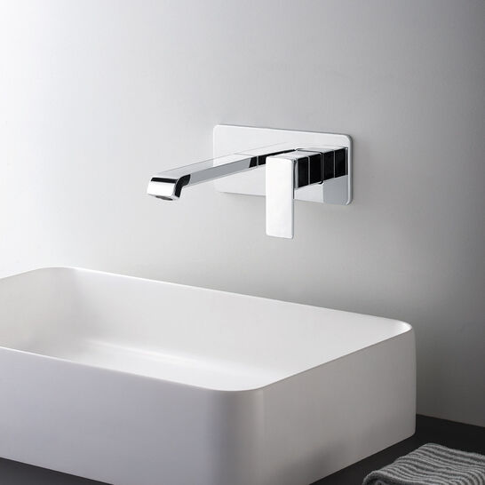 Rechteckiges, modernes Waschbecken mit Wandarmatur in Chromoptik. Minimalistisches Design auf dunkler Oberfläche. Daneben liegt ein kleines Handtuch. Rechteckiges, modernes Waschbecken mit Wandarmatur in Chromoptik. Minimalistisches Design auf dunkler Oberfläche. Daneben liegt ein kleines Handtuch.
