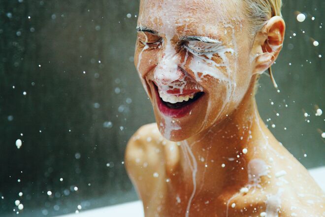 Das Bild zeigt eine Person, die unter Wasser oder Schaum lacht. Es wirkt, als ob sie Spaß beim Duschen oder Baden hat. Die Augen sind geschlossen und das Gesicht ist mit Schaum bedeckt. Das Bild zeigt eine Person, die unter Wasser oder Schaum lacht. Es wirkt, als ob sie Spaß beim Duschen oder Baden hat. Die Augen sind geschlossen und das Gesicht ist mit Schaum bedeckt.