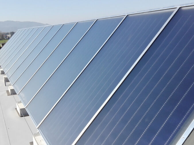 Eine Reihe von Solarpanelen auf einem Dach, ausgerichtet zur optimalen Energiegewinnung, mit einer Landschaft und Bergen im Hintergrund. Eine Reihe von Solarpanelen auf einem Dach, ausgerichtet zur optimalen Energiegewinnung, mit einer Landschaft und Bergen im Hintergrund.